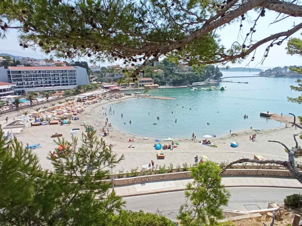 a beach with a bunch of people in the water at Sobe Ruža in Banjol