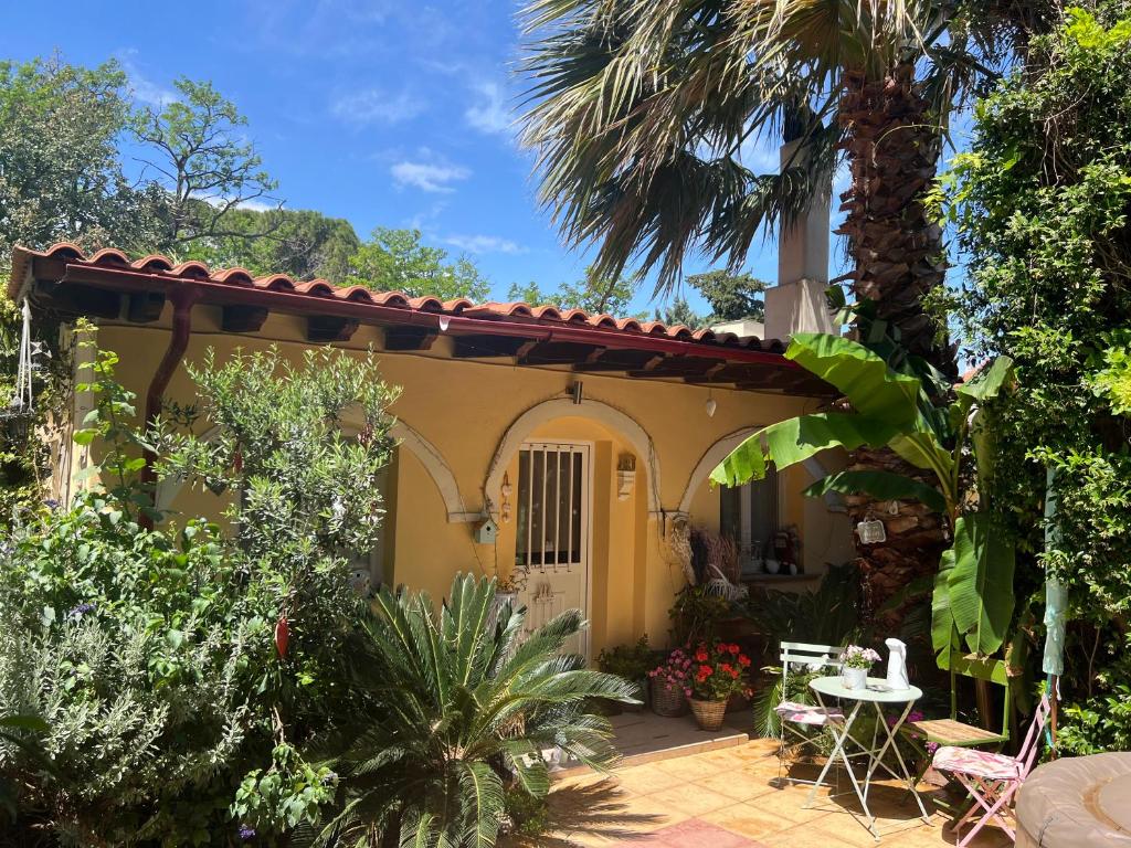 ein Haus mit einer Terrasse und einer Palme in der Unterkunft PJ GARDEN HOUSE in Athen