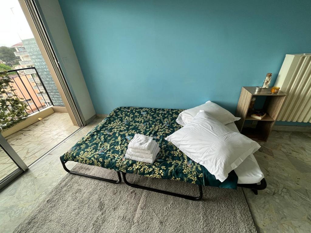 una cama con almohadas en una habitación en Appartement 10 min Croisette, en Le Cannet