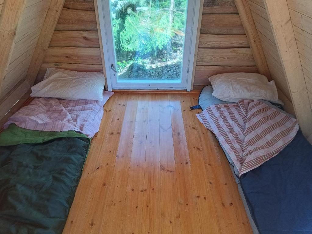 two beds in a tiny house with a window at Korjuse Moor in Korjuse