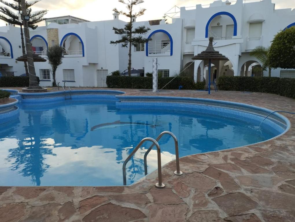 a swimming pool in front of a building at Naila in Sidi Bouzid