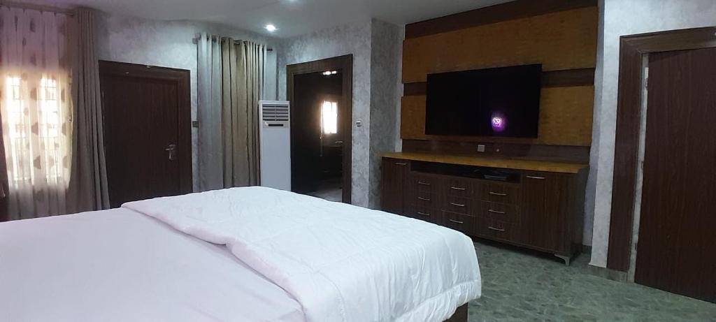 1 dormitorio con 1 cama y TV de pantalla plana en Tourista Travel and Tours, 