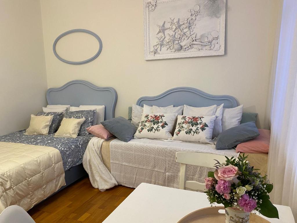 sypialnia z 2 łóżkami i stołem z kwiatami w obiekcie Kwatera Prywatna Maja w mieście Sopot