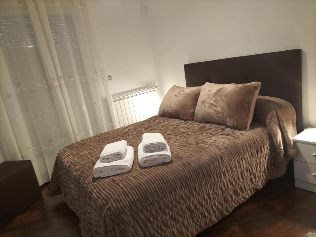 een slaapkamer met een bed met twee handdoeken erop bij CASA vila in Riópar