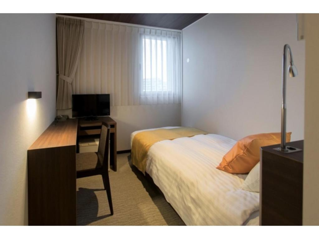 盛岡市にあるKITA HOTEL - Vacation STAY 69747vのベッドと机、テレビが備わったホテルの部屋