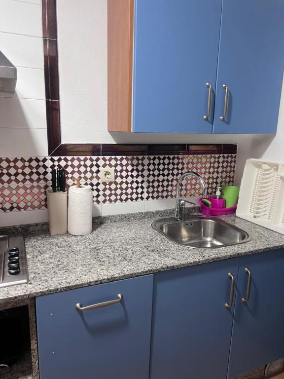 a kitchen with blue cabinets and a sink at Apartamento Zahara in Zahara de los Atunes