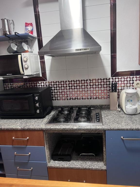 a kitchen with a stove and a microwave at Apartamento Zahara in Zahara de los Atunes