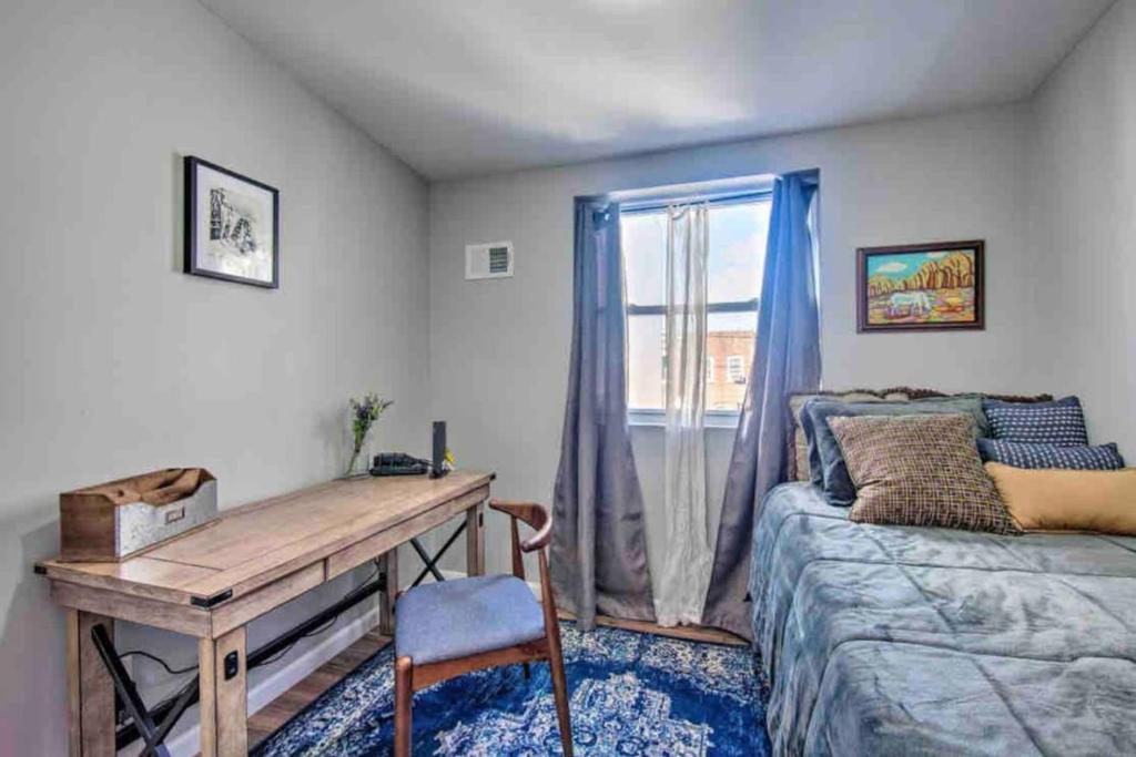 a bedroom with a desk and a bed and a window at Modern South Philly Townhome in Philadelphia