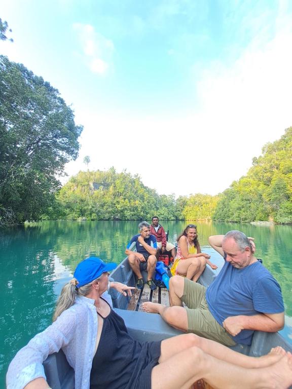a group of people sitting on a boat in the water at Maricho Homestay in Besir