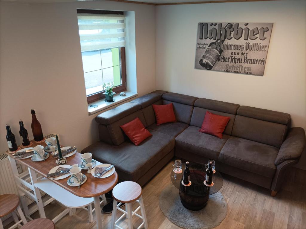 uma sala de estar com um sofá e uma mesa em Apartment Bräustübel, free Wi-Fi, Parken, Grillecke, nähe Rennsteig em Lehesten