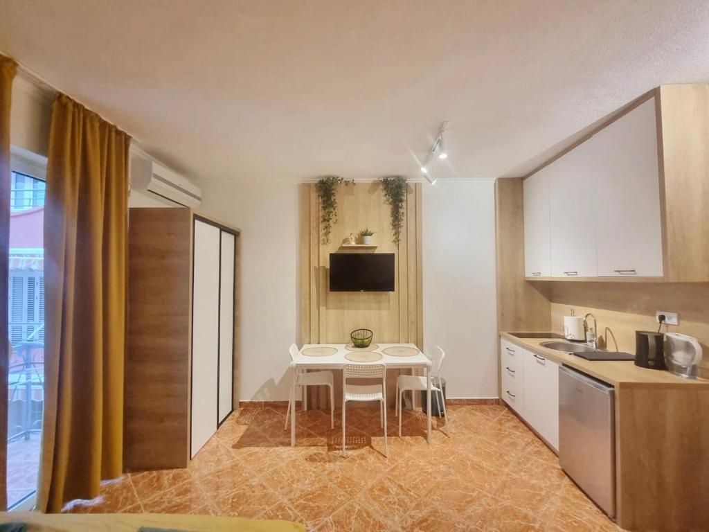 - une cuisine avec une table blanche, une table et un évier dans l'établissement Studio apartman na plaži, à Rafailovici