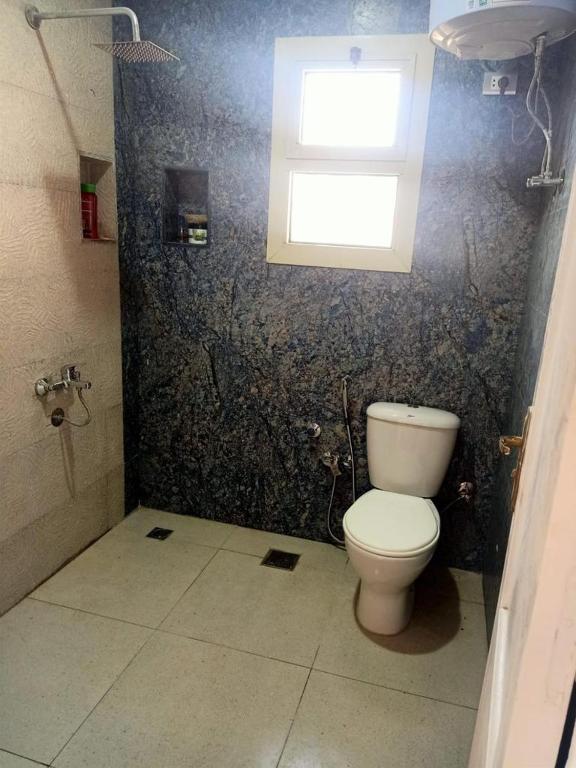 a bathroom with a toilet and a window at فيلا مريم in Cairo