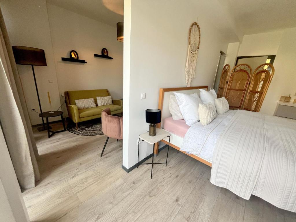 Nieuw! The West Wing Bloemendaal في بلومندال: غرفة نوم مع سرير وغرفة معيشة