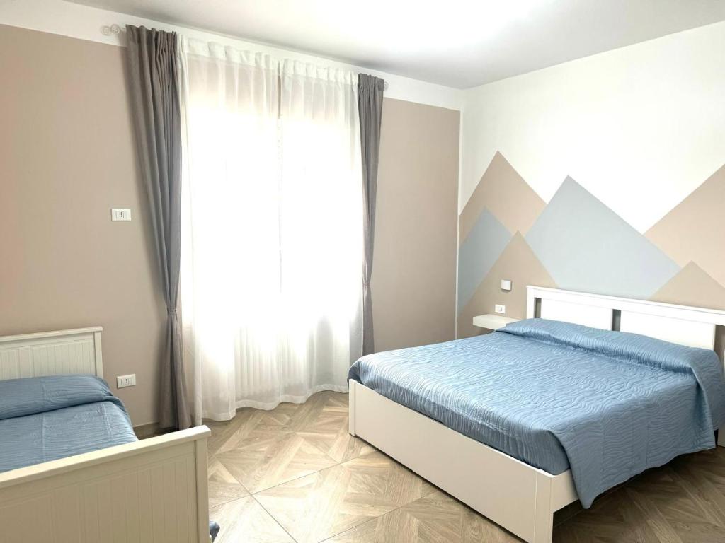 1 Schlafzimmer mit 2 Betten und einem Fenster mit Bergblick in der Unterkunft civico 250 in Pescara