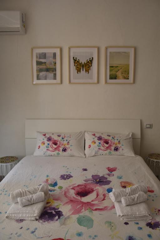 Un dormitorio con una cama con flores y mariposas. en Il Girasole, en Iglesias