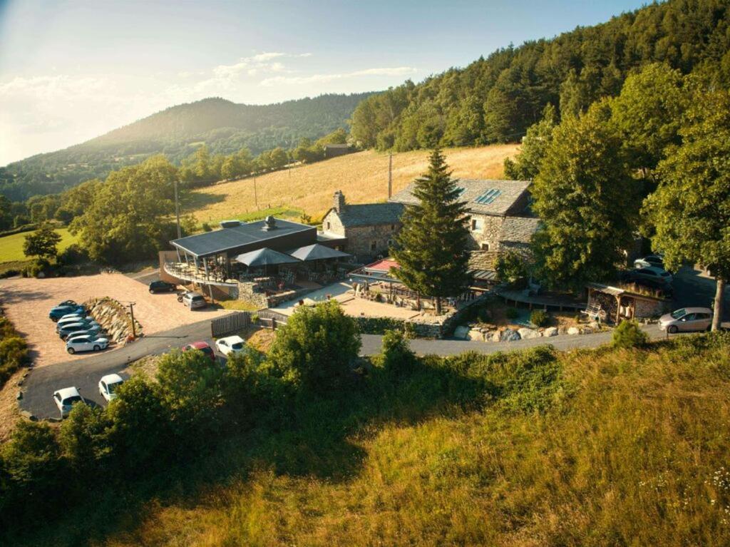 una vista aérea de un edificio con coches en un aparcamiento en La Ferme du Bien-etre en Saint-Julien-Chapteuil