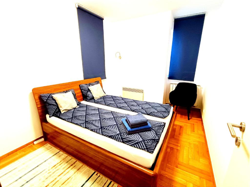 a bed with black and white sheets and pillows at LuxApart Bascarsija Old City Centar free parking in Sarajevo