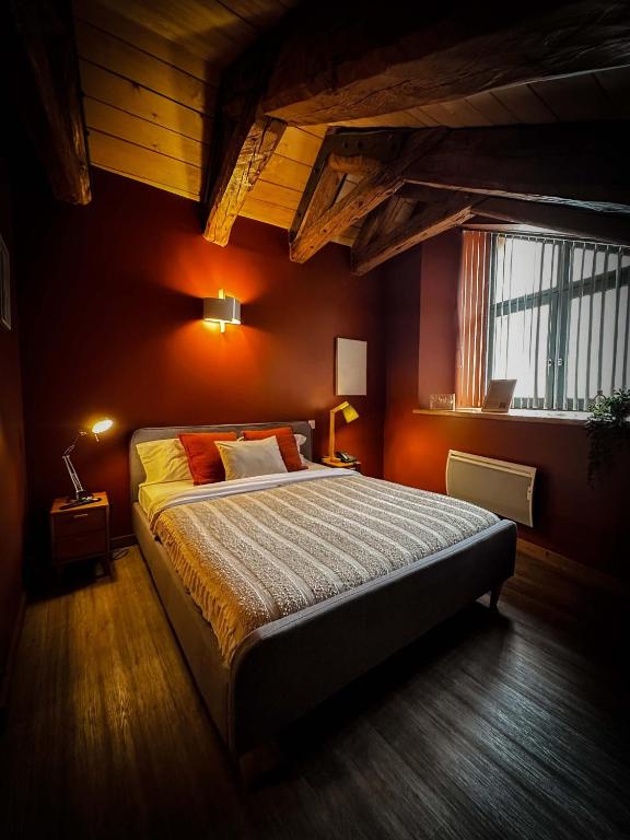 a bedroom with a large bed with orange walls at La Ferme du Bien-etre in Saint-Julien-Chapteuil