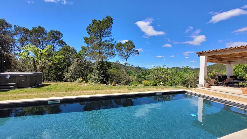 a swimming pool with a view of a yard at Maison Clair de Lune in Cabasse