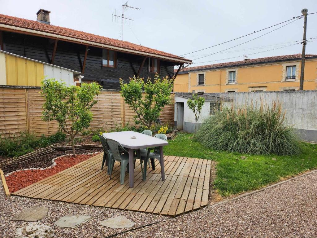 a patio with a table and chairs in a yard at Maison de campagne in Norrois