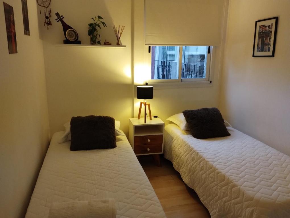 2 camas en una habitación pequeña con ventana en Humboldt en Buenos Aires