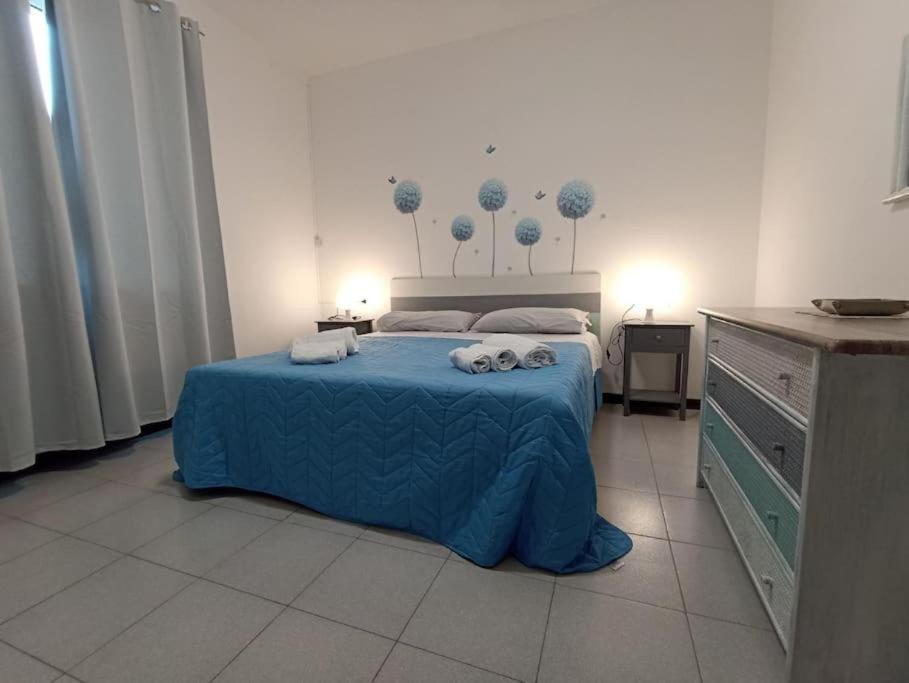 een slaapkamer met een blauw bed en handdoeken bij Appartamento al mare civico28 in Porto Recanati