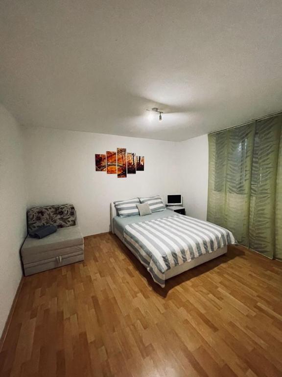 a bedroom with a bed and a chair in it at Apartman Amela in Mostar