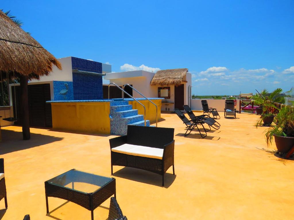 a patio with chairs and tables on top of a building at Villas ponto in Holbox Island