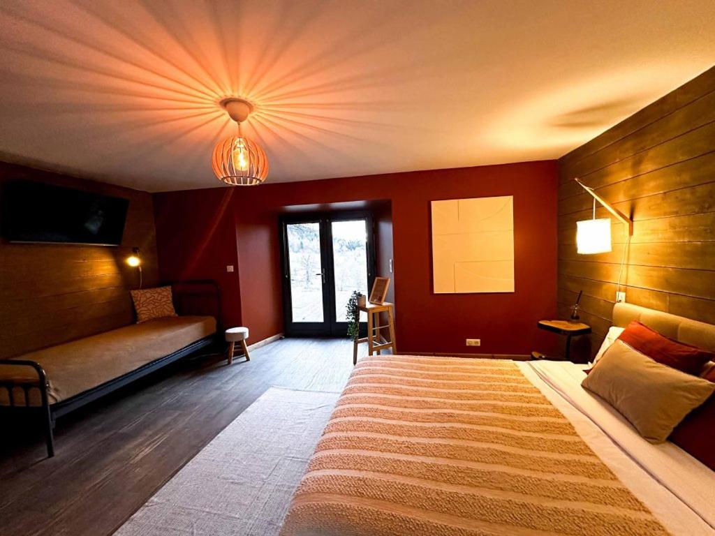 a bedroom with a large bed and a couch at La Ferme du Bien-etre in Saint-Julien-Chapteuil