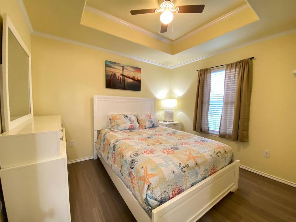 une chambre avec un lit et un ventilateur de plafond dans l'établissement Horizon Cottage #3, à Rockport