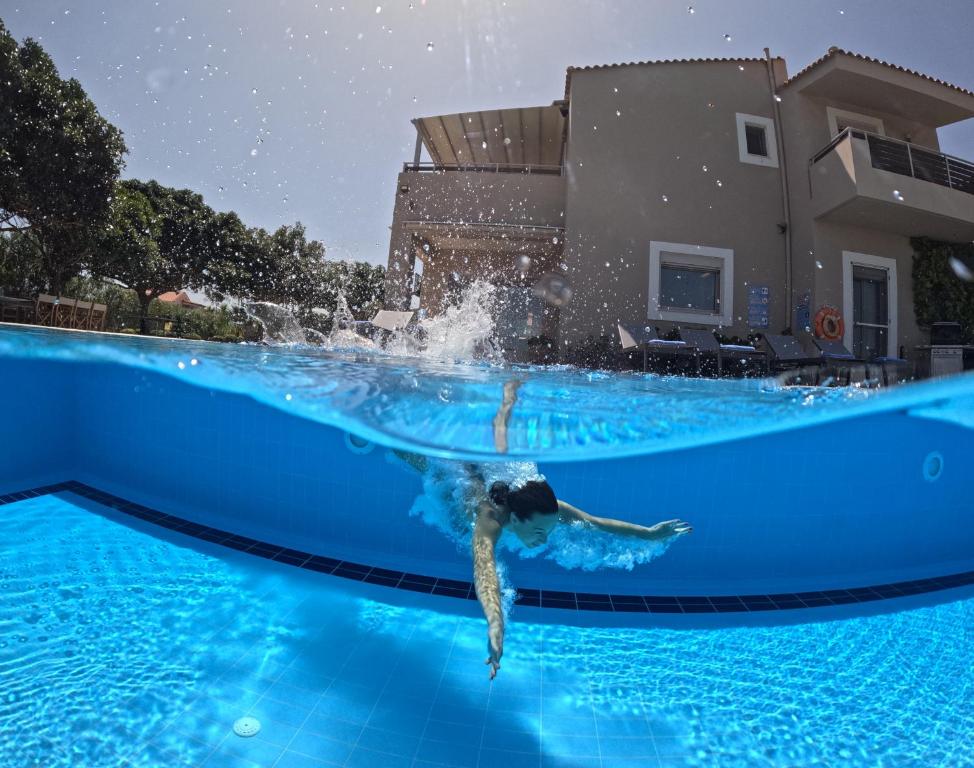 uma pessoa a nadar numa piscina em Four Seasons private villa - seaview - big heated pool - gym - sport activities em Gouves