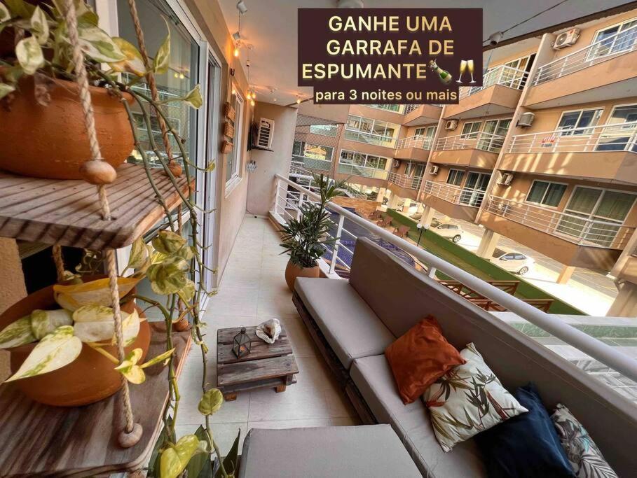 Un balcón de un apartamento con sofá y plantas en Muito Ventilado, Wifi 300mb, Até 5 pessoas + Pet, en Caucaia