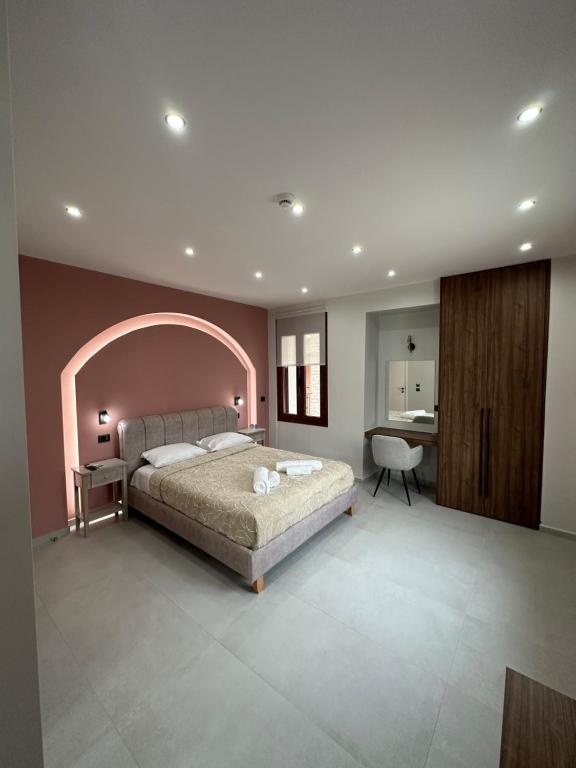 1 dormitorio con 1 cama grande y escritorio en Incanto Luxury Suites 2 en Nafpaktos