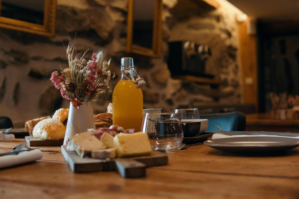 a table with cheese and a bottle of orange juice at La Ferme du Bien-etre in Saint-Julien-Chapteuil