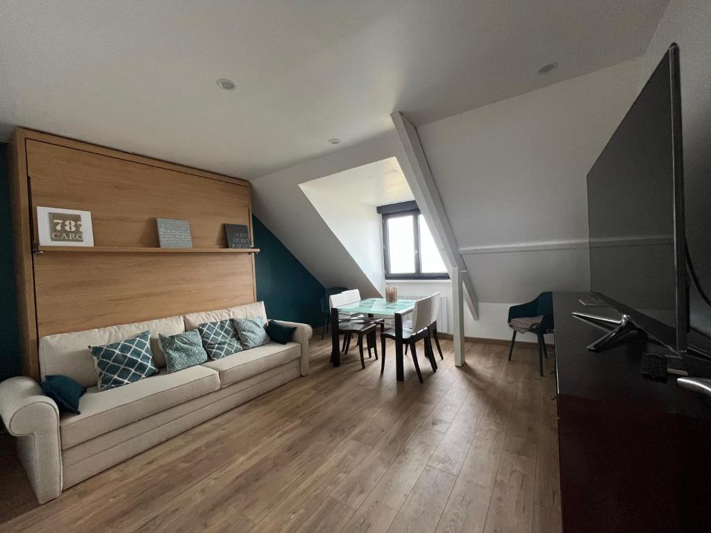 un salon avec un canapé et une table dans l'établissement En bord de mer, vue et accès direct à la plage, à Batz-sur-Mer