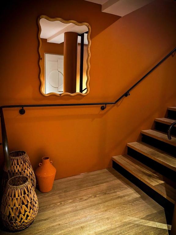 a room with a mirror on the wall and stairs at La Ferme du Bien-etre in Saint-Julien-Chapteuil