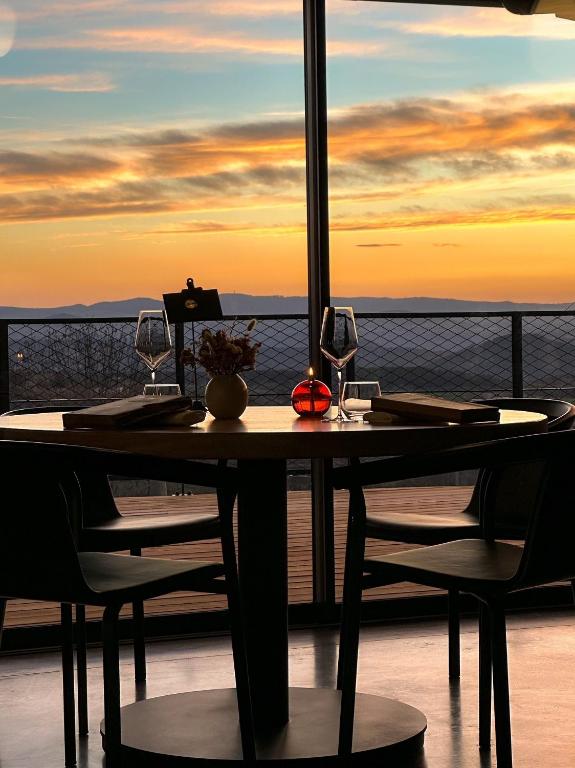 a table with two wine glasses on a balcony at La Ferme du Bien-etre in Saint-Julien-Chapteuil