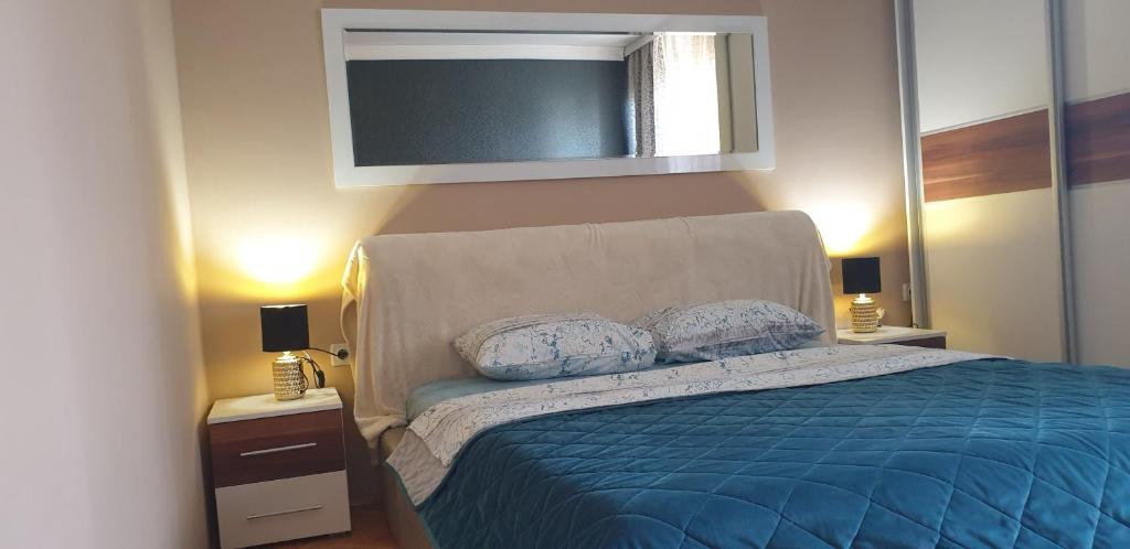 a bedroom with a blue bed with two pillows at Apartment Stan na dan in Niš