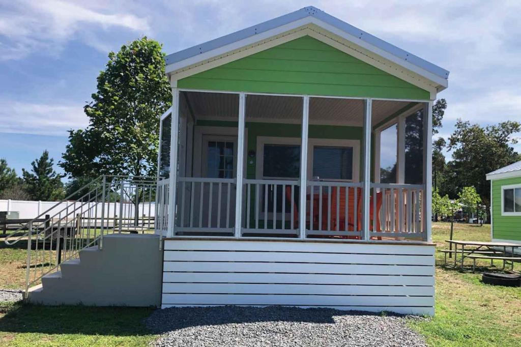 a small green and white building with a porch at Sun Outdoors Rehoboth Bay in Millsboro