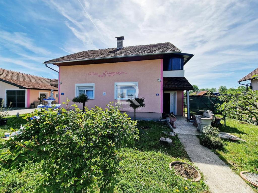 uma pequena casa cor-de-rosa com telhado em Villa Dalmacija em Prijedor