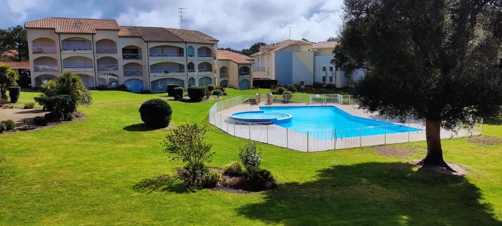 un grand bâtiment avec une piscine dans une cour dans l'établissement Appartement Moliets plage, avec piscine, à Moliets-et-Maa