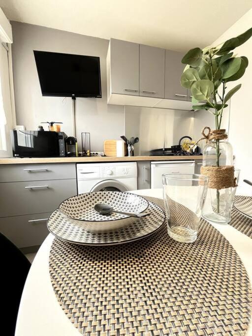 - une cuisine avec une table avec un bol et des assiettes dans l'établissement Studio Lumière du Centre - Parking - Romans, à Romans-sur-Isère