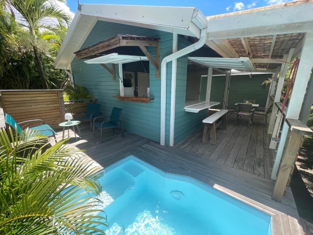 une maison avec une piscine et une terrasse dans l'établissement Très joli bungalow et sa petite piscine privee, à Rivière-Salée