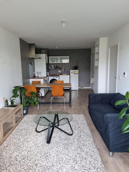 een woonkamer met een blauwe bank en oranje stoelen bij Appartement en résidence - Trappes in Trappes