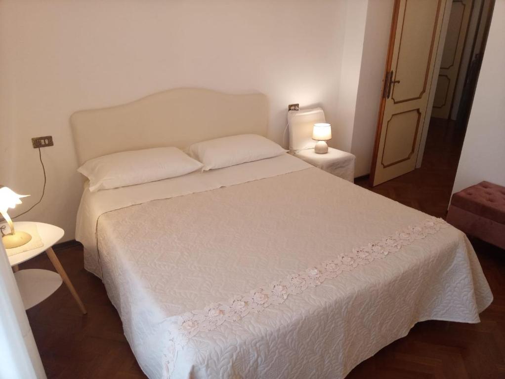 a bedroom with a white bed with two pillows at Angela Home in Rimini