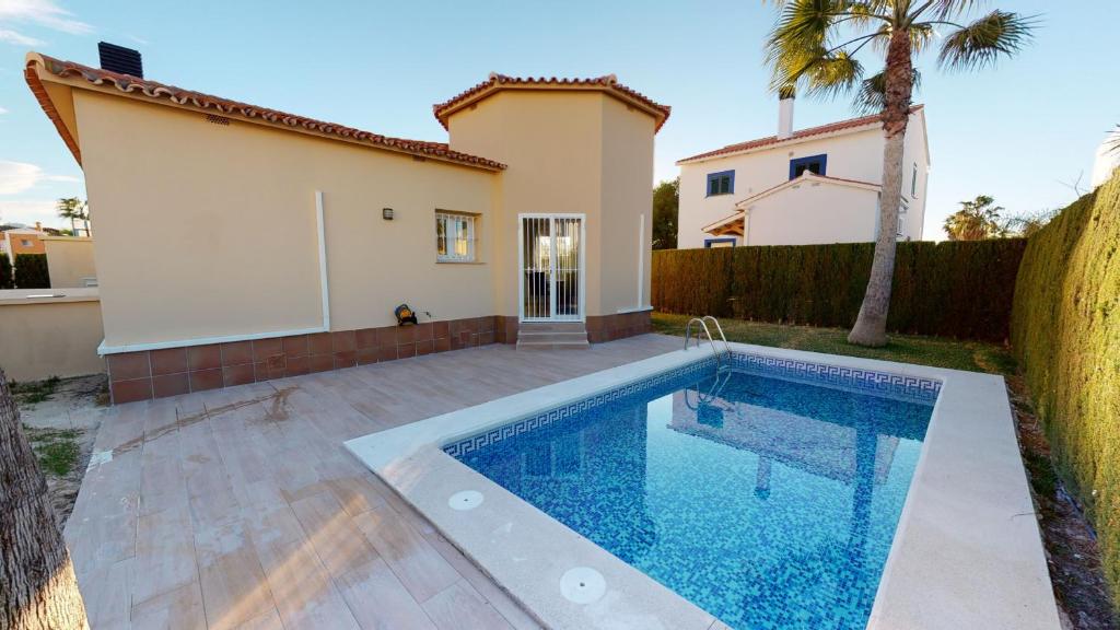 a swimming pool in front of a house at Villa Cisne by ON Travel in Casas Devesa