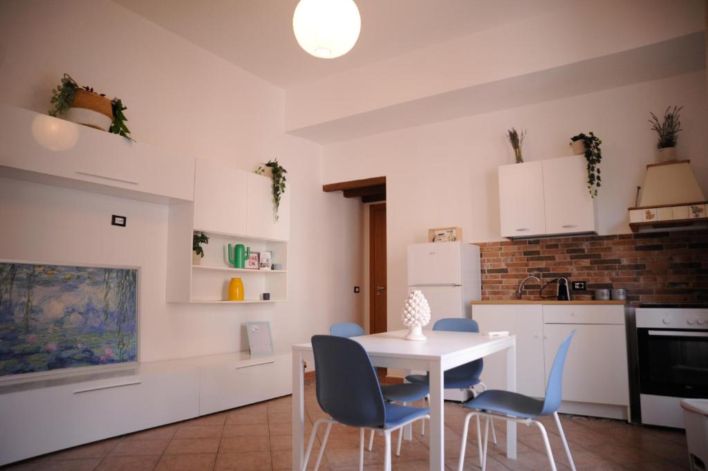 eine Küche mit einem weißen Tisch und blauen Stühlen in der Unterkunft Le Finestre su Ballarò in Palermo