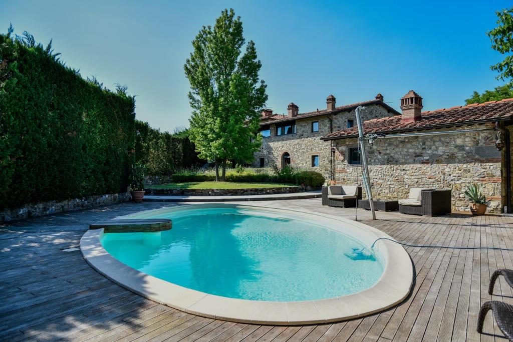 a swimming pool in a yard with a house at Appartamento in Villa con Piscina - Mhateria Relais in Rignano sullʼArno