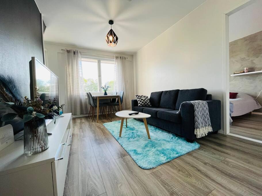 uma sala de estar com um sofá e uma mesa em Fresh apartment 450m to Turku bus station em Turku
