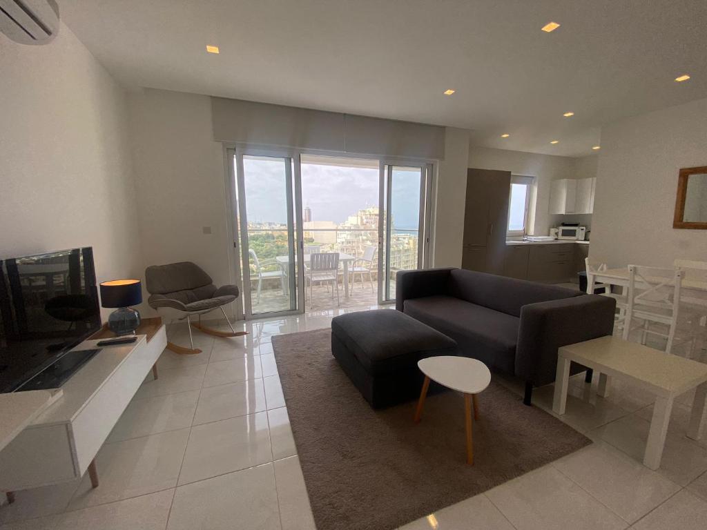 ein Wohnzimmer mit Couch und Fernseher in der Unterkunft Spectacular Distant Seaview Apt in Sliema